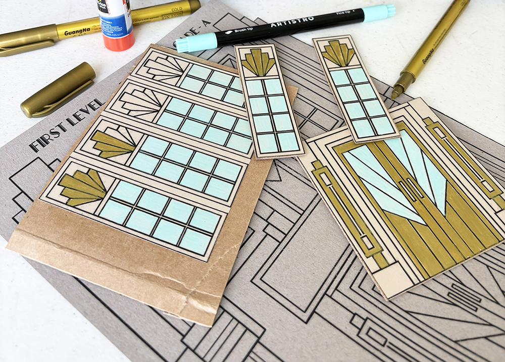 Art Deco windows mounted onto cardboard as a group before final cutting, alongside individually cut windows and a door.
