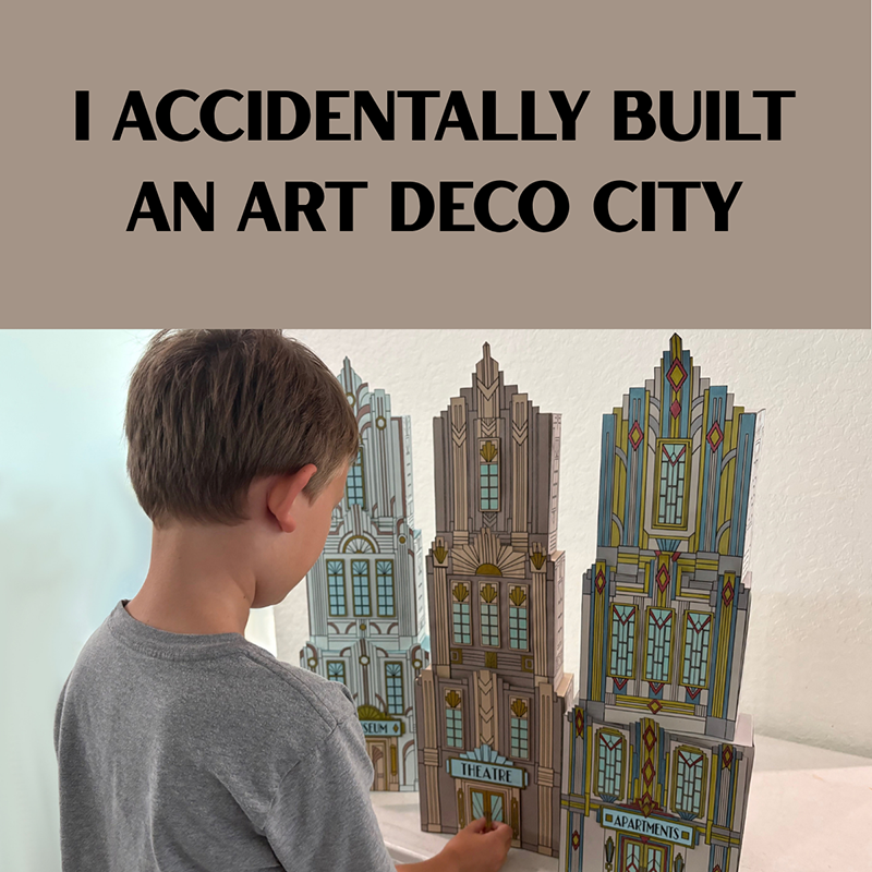 Child standing beside three tall handmade Art Deco paper skyscrapers created for the Zappy Arts Art Deco Art History Lesson.